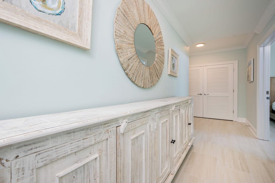 Discover a charming entryway featuring coastal decor and a stylish cabinet, welcoming you to your beach retreat