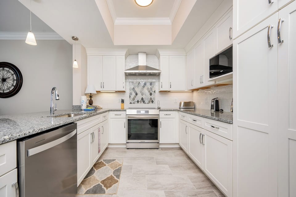 Prepare meals in this kitchen featuring granite countertops, upgraded appliances, and stylish decor