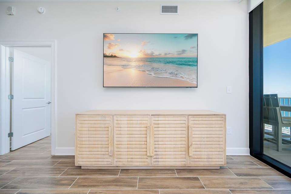 Enjoy the serene ambiance with a stylish TV mounted above a natural wood cabinet for streaming your favorite show