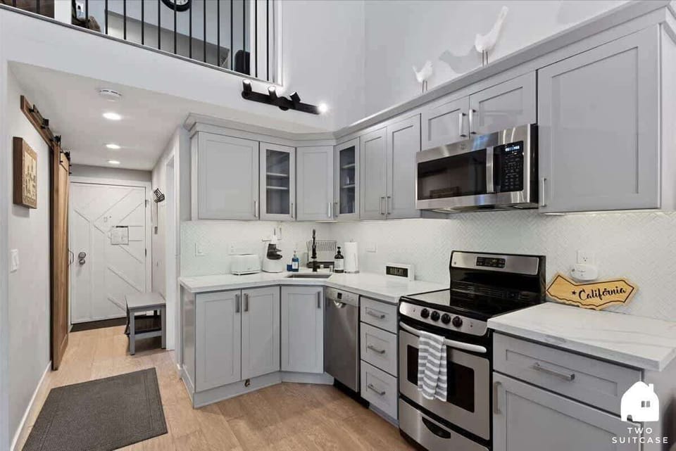 Step into a bright, welcoming kitchen where warm wood floors meet contemporary design. 🚪
