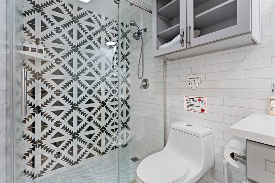A clean, spacious shower area with elegant tiling and chrome fixtures. 🚿