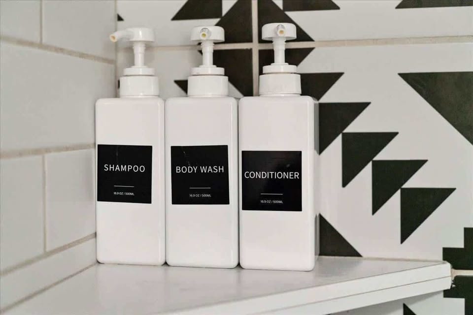 Modern, monochrome soap dispensers beside a sleek sink with bold geometric tile. 🧼