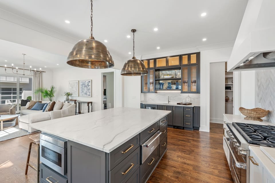 The kitchen has a large island with storage and appliances embedded.