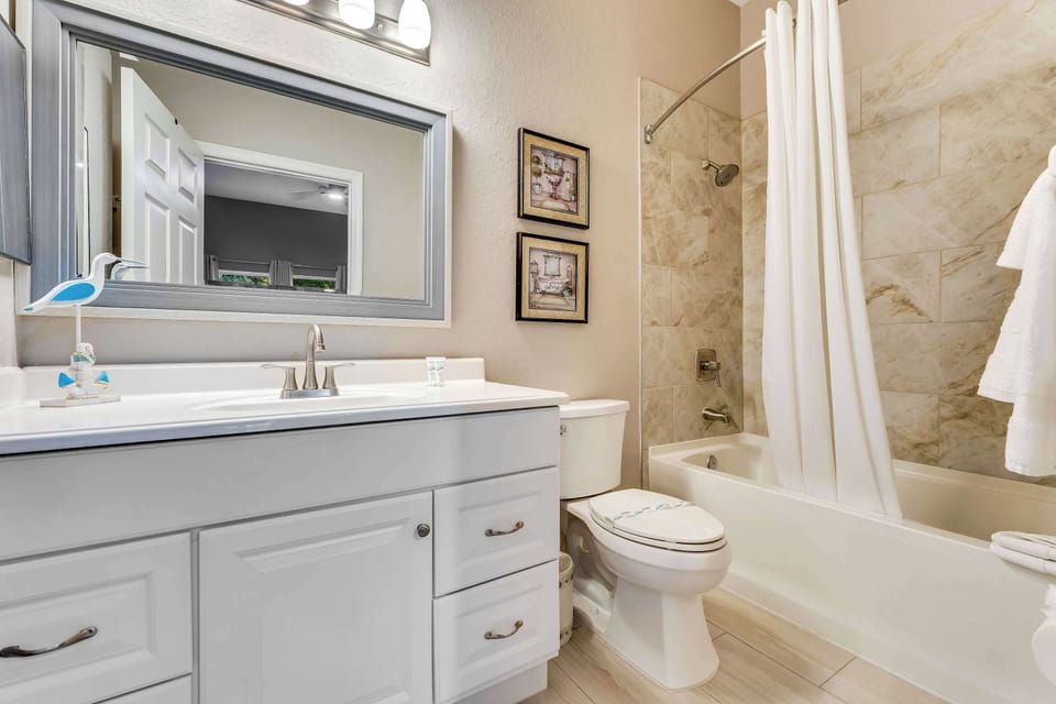 This tranquil ensuite bath includes a single vanity & shower/tub combo
