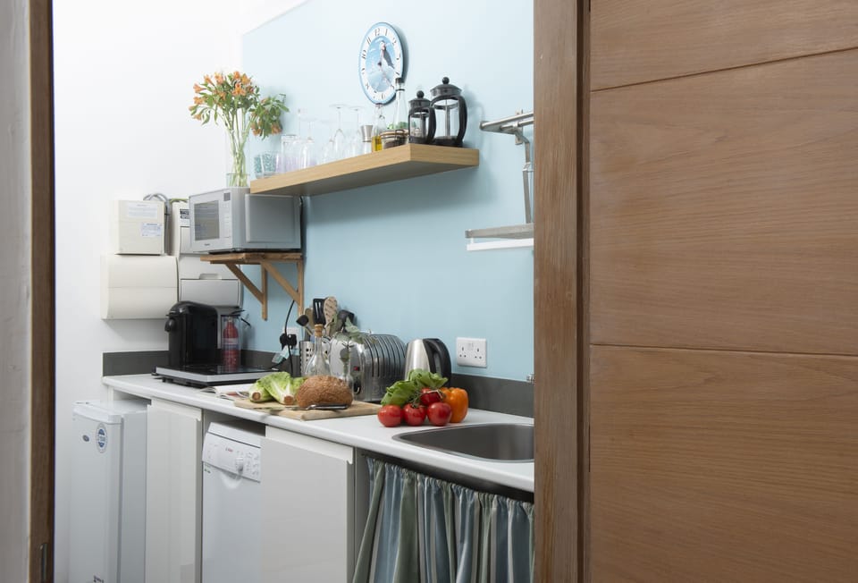 The Perch at Rockside, Polzeath: Kitchen with electric hot plates, microwave, fridge, slimline dishwasher, and Nespresso Vertuo coffee machine