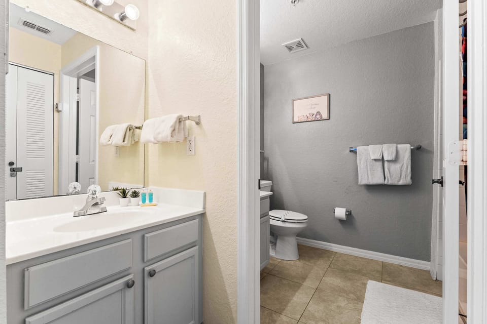 Shared bathroom w/ shower/tub combo & an additional separate vanity area