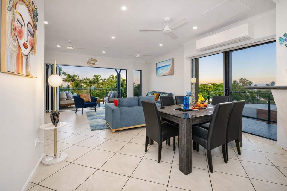 Bright open-plan living and dining area with large doors that can be opened to capture cooling sea breezes.