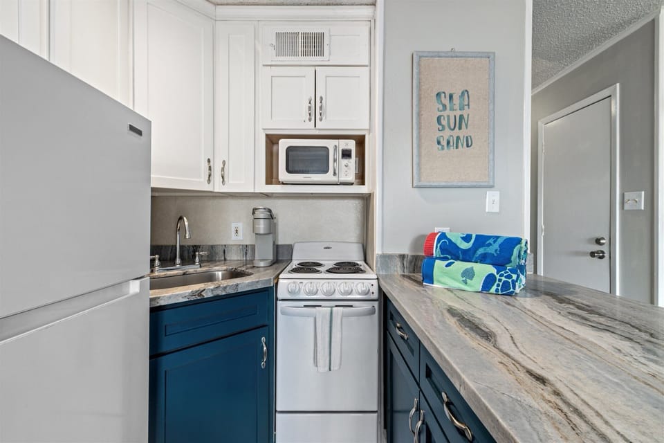 Kitchen with range, microwave, and fridge