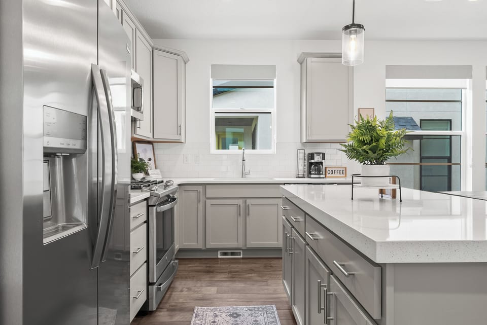 A well appointed chefs kitchen with upgraded stainless steel appliances and fully stocked