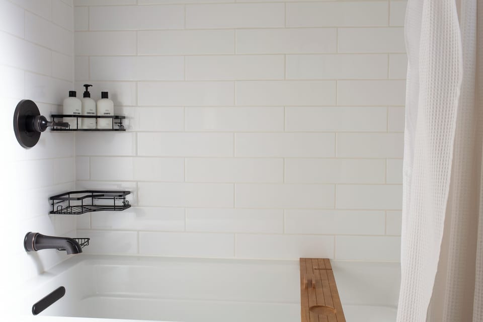 A clean, modern bathtub with high-end toiletries.