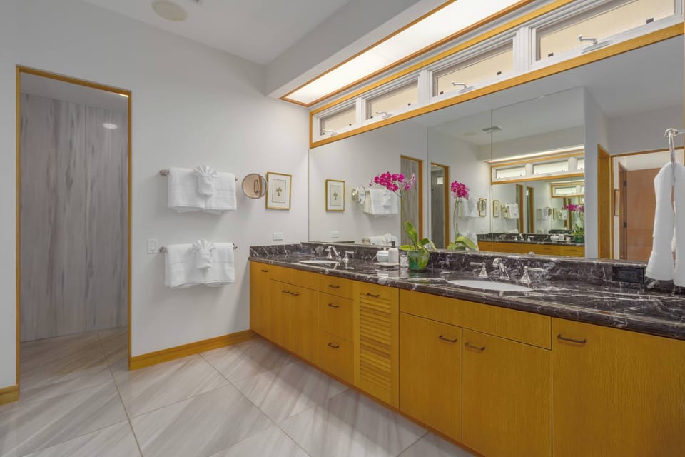 The primary bedroom has a spa-inspired ensuite with dual sinks and a beautifully tiled walk-in shower.
