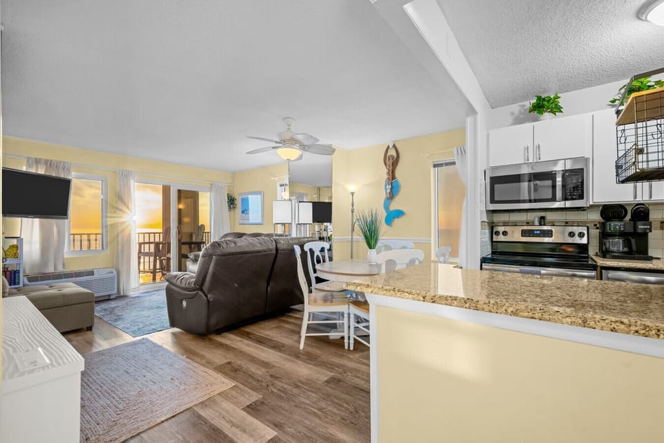 Fully equipped kitchen with breakfast bar flowing into a welcoming living space—ideal for meals, games, and relaxing after the beach.
