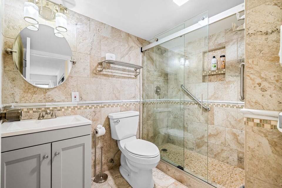 Spa-style bathroom with a beautifully tiled walk-in glass shower—clean, modern, and designed for comfort.