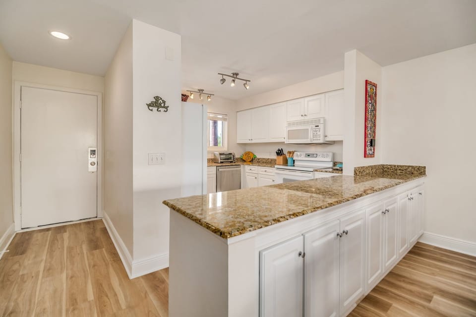 Updated white kitchen with granite counters and breakfast bar - fully equipped for vacation cooking