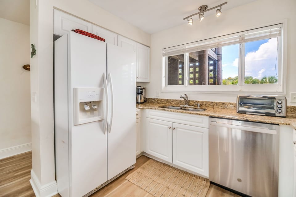 Updated white kitchen with granite counters and breakfast bar - fully equipped for vacation cooking