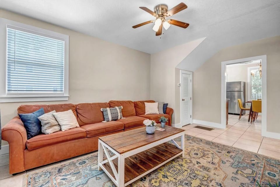 - Cozy up in this comfy living room with a plush sectional, ceiling fan, & vibrant rug
- Natural light pours in through windows to brighten every moment indoors
- Ideal for movie nights, casual chats, or recharging between your local outings