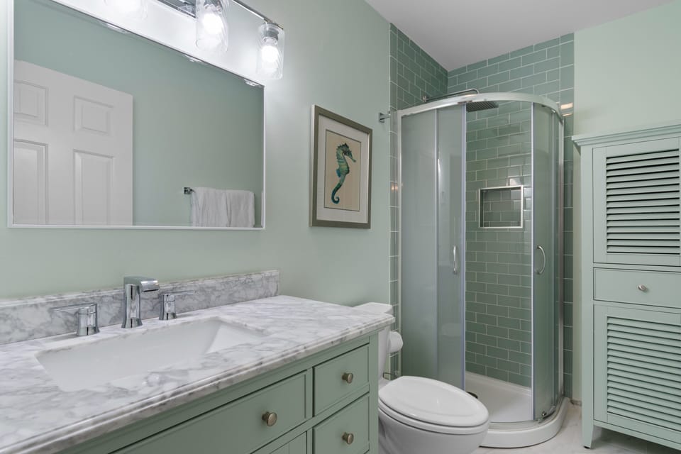 Your spa-inspired bathroom features marble countertops, rainfall shower, and soothing coastal colors for ultimate relaxation.