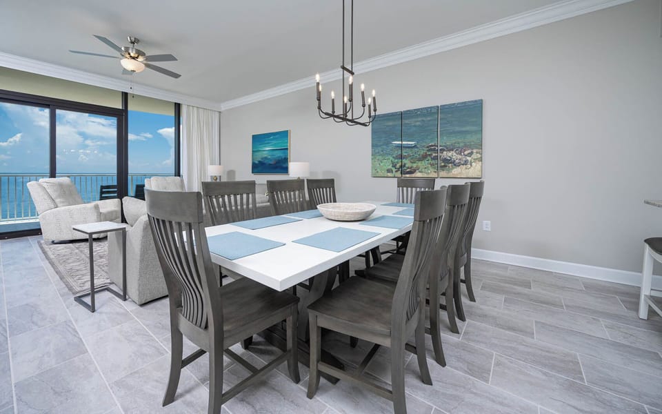 Dine at the large table surrounded by comfortable chairs, with beachfront views creating lasting memories