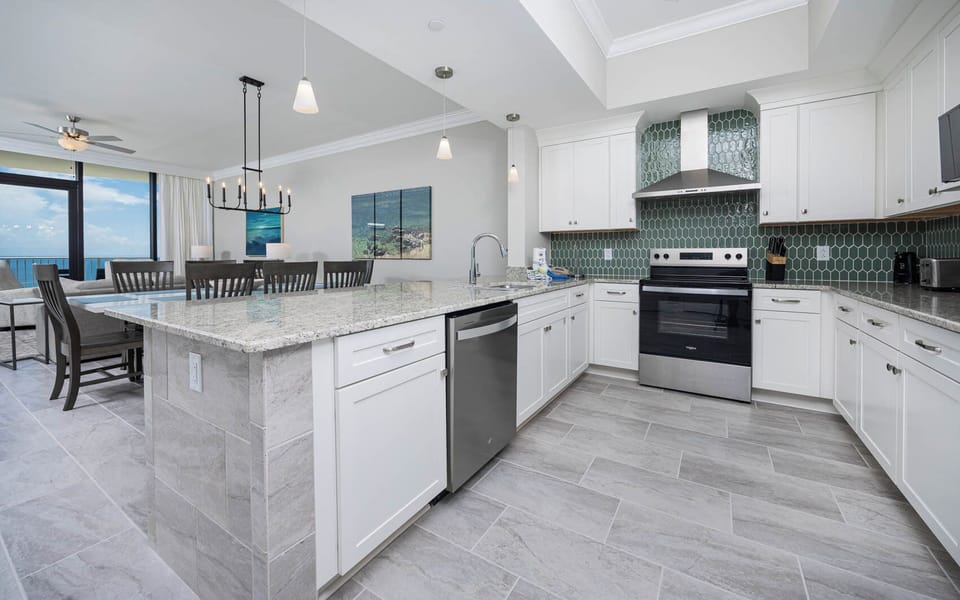 Prepare meals in this elegant kitchen with beautiful beach views, spacious counters, and a stylish backsplash