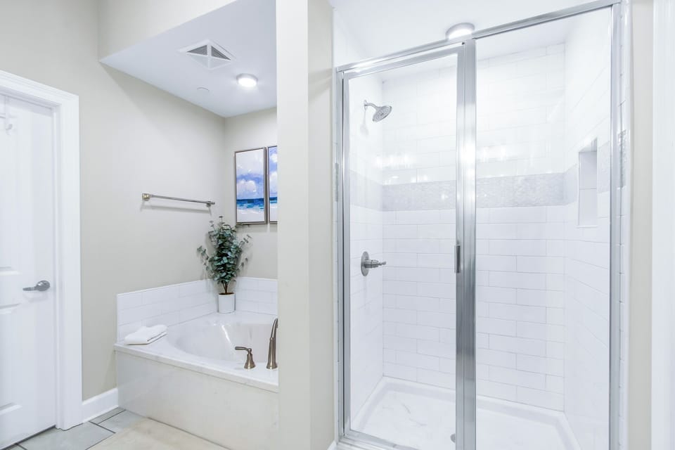 Stylish master bath featuring a relaxing tub, a walk-in shower, and elegant decor for a comfortable stay