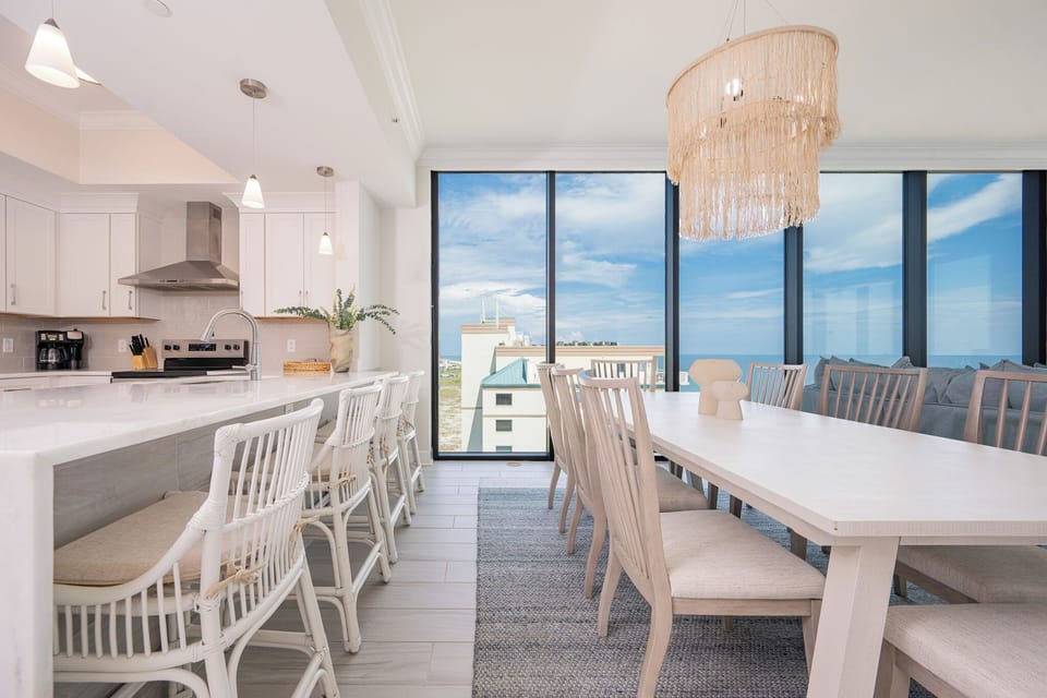 Gather around the spacious dining table or breakfast bar, enjoying the stunning panoramic beach views