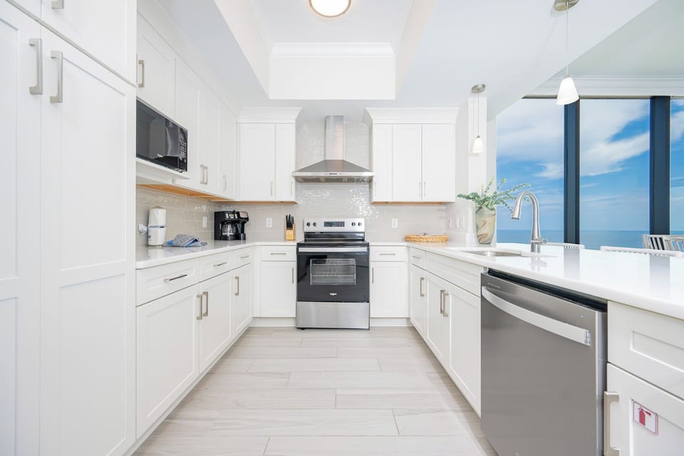 Prepare meals while enjoying captivating beach views through large windows in this bright kitchen space