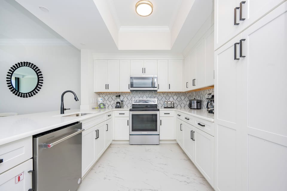 Prepare meals in this stylish kitchen featuring sleek cabinetry, stainless appliances, and a chic backsplash