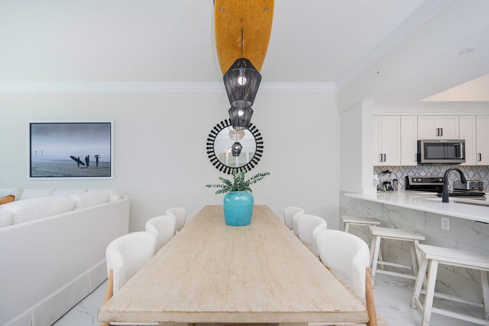 Dine at the spacious wooden table, accented by a vibrant vase and stylish decor, perfect for gatherings with family