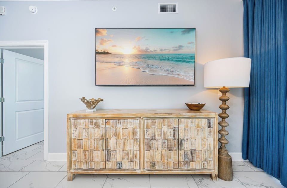 Enjoy the stylish decor with a wooden cabinet, a large TV, and a unique lamp, creating a welcoming vibe