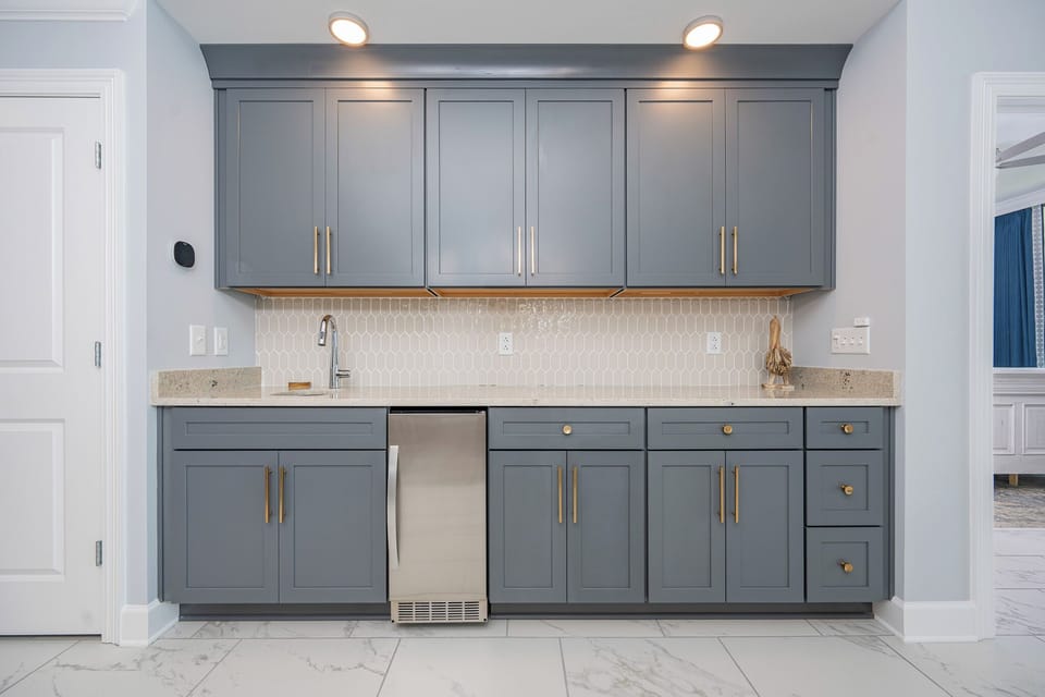 Prepare your favorite drinks at this stylish wet bar featuring sleek cabinetry and elegant countertops
