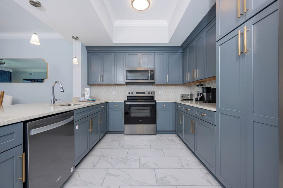 Prepare meals in this stylish kitchen featuring ample counter space, stainless appliances, and elegant cabinetry