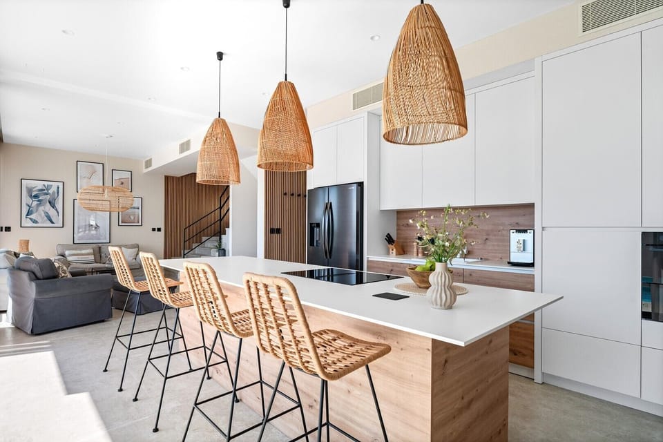 And a fully equipped kitchen with a spacious kitchen island and four stools.