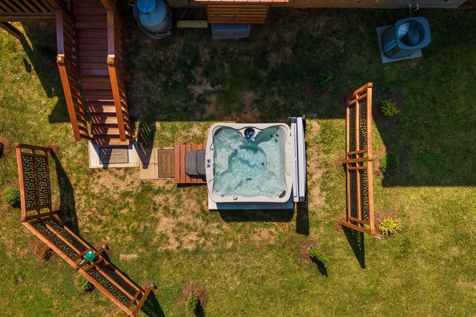 Aerial view of the outdoor spa tub. Two privacy screens surround it.
