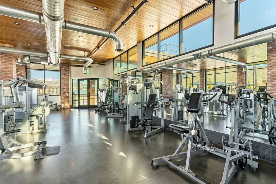 Spacious gym w/ cardio machines, weights & large windows for energized workouts