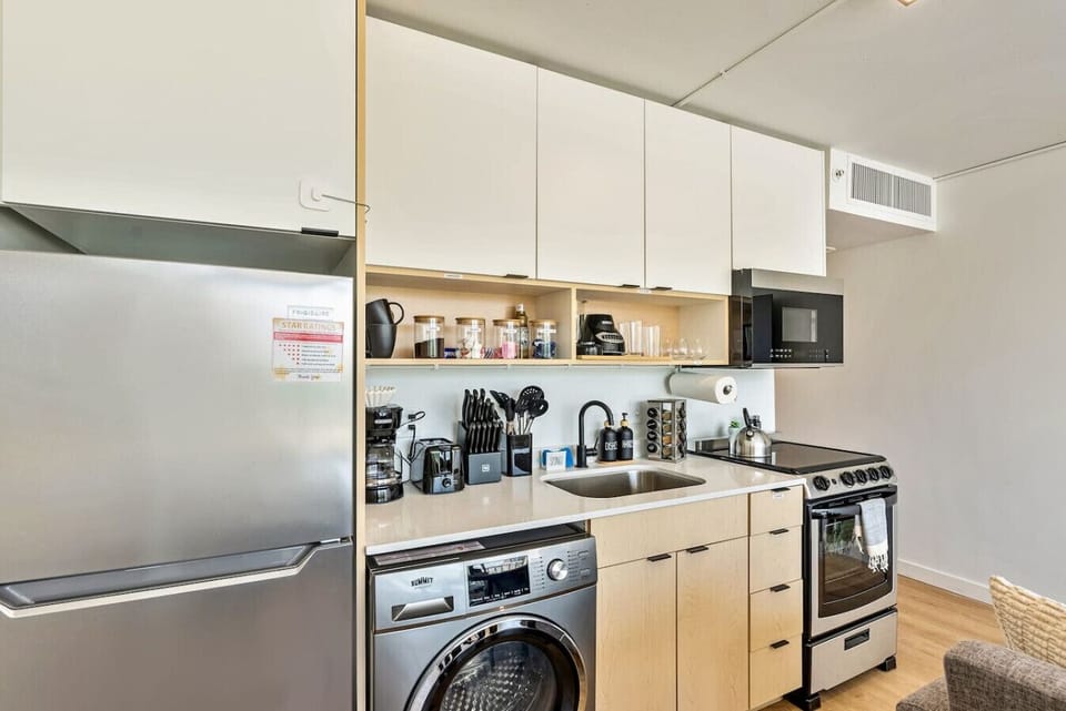 Sleek kitchen w/ stainless appliances, open shelving & everything within easy reach