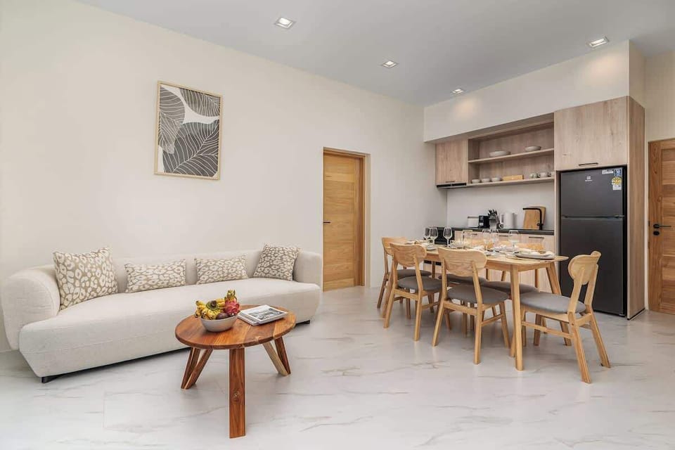 The living room is designed for relaxation and entertainment, featuring a smart TV that provides access to international channels and popular streaming services. 