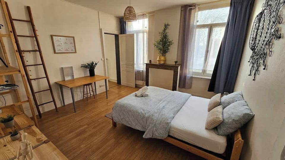 Chambre avec lit double et espace bureau.