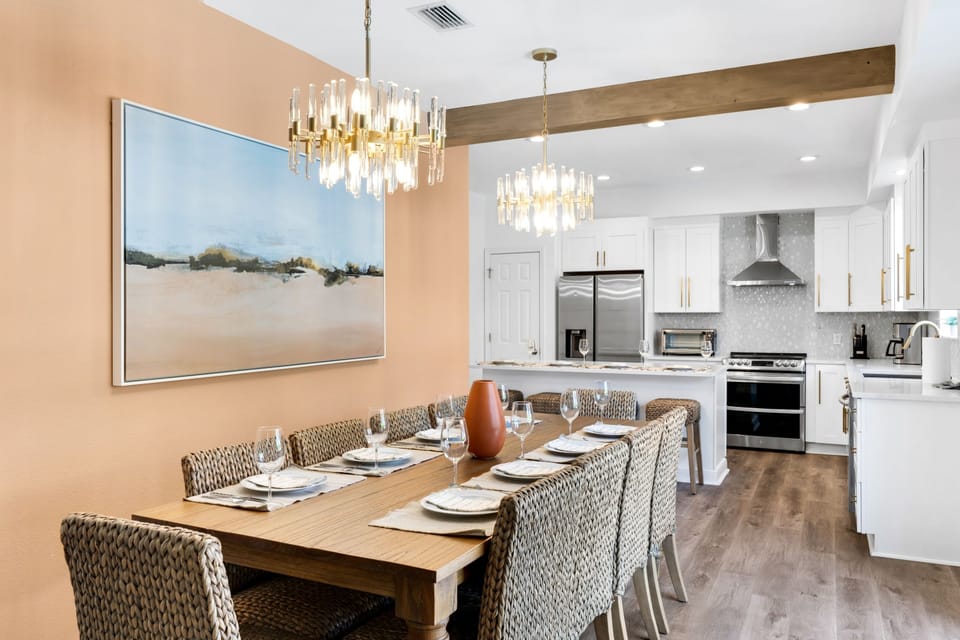 Gather around the 8-seater dining table, brightened by great lighting and a stylish chandelier—perfect for meals and memories! | White Sands, Paradise Isles, Destin | Voyax Luxury Vacation Rentals