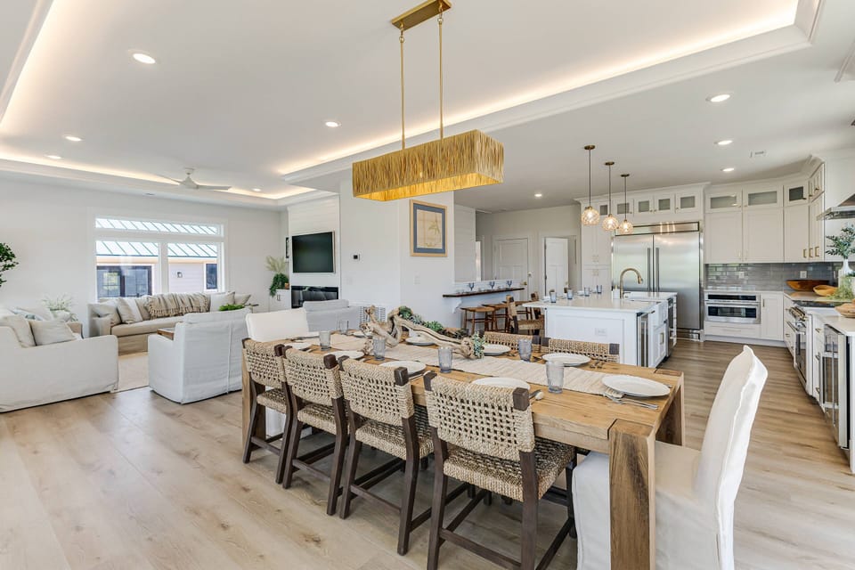 This grand dining table seats 10. The open concept floor plan creates an airy & inviting space to be together.