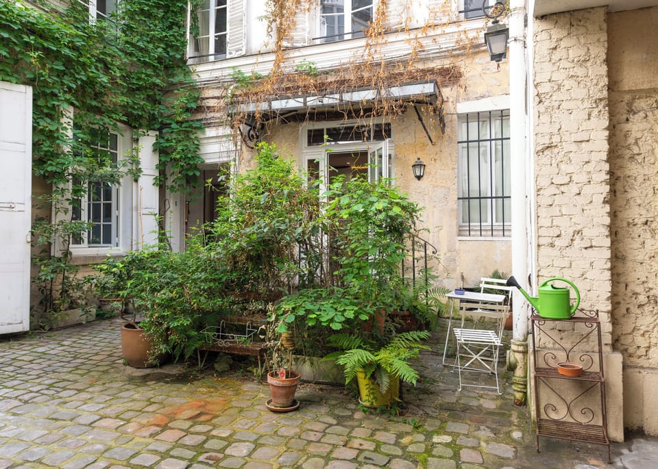 The entrance of the studio and the nice greeneries of the building's courtyard.