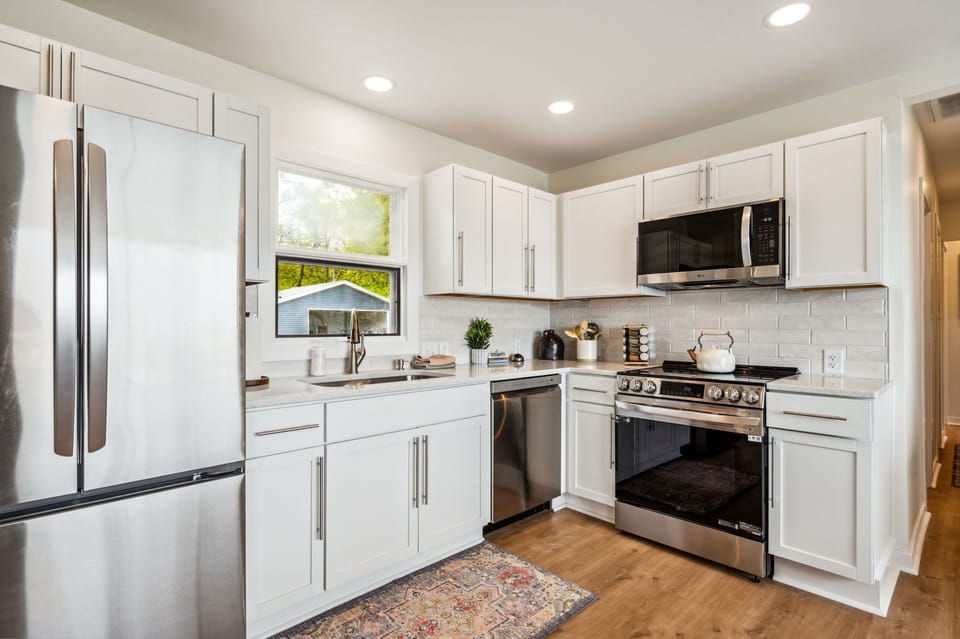 Spacious kitchen with stone counters and stainless appliances. Just steps from the Sand Bay shoreline.