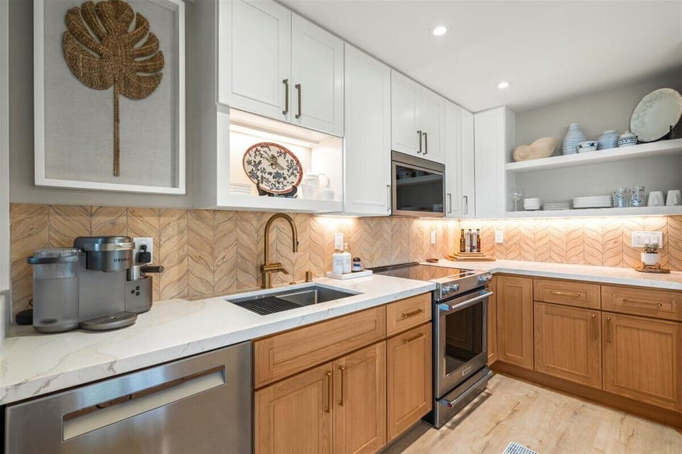 Stainless steel appliances with elegant tiled backsplash