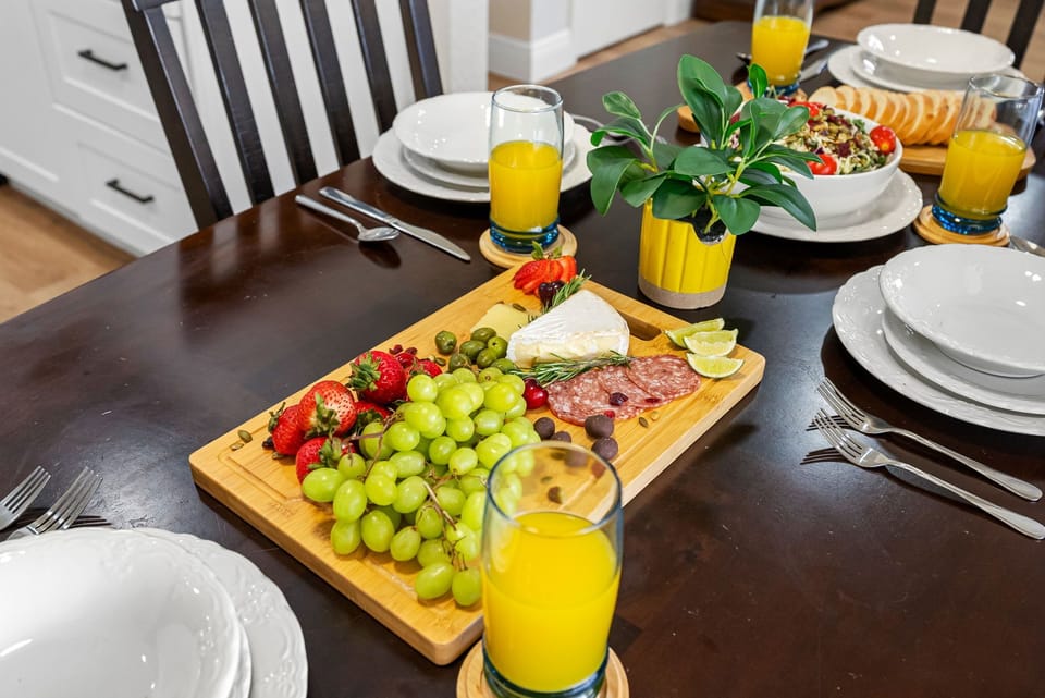 The dark wood dining table comfortably seats four and is surrounded by padded high-back chairs that invite lingering meals and good conversation.
