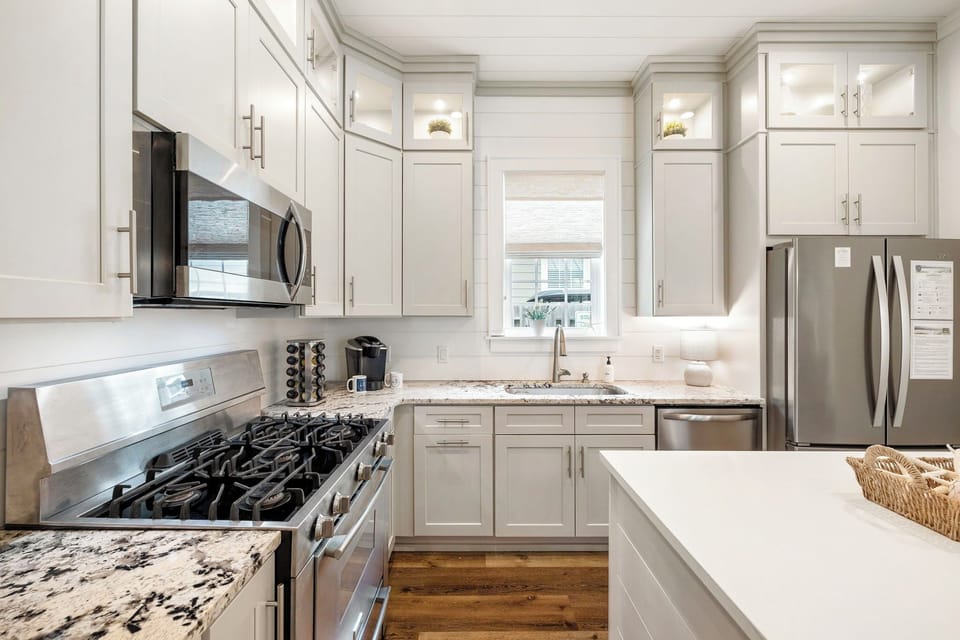 Bright and airy kitchen with custom cabinetry, sleek appliances, and an open flow that connects seamlessly to the cozy living space.