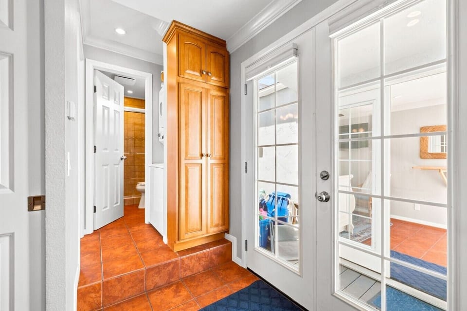 Bright hallway leading to the private patio and laundry area, with french doors bringing in natural light.