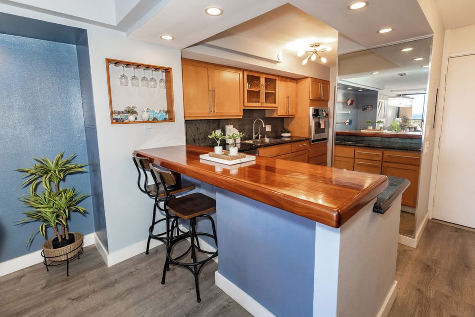 Start your day with coffee or cocktails at this inviting bar counter with rich wood finishes and comfy stools—just steps from the kitchen.