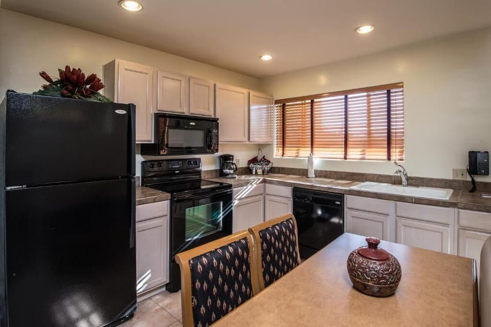 This well-appointed kitchen features modern appliances and a cozy dining area, perfect for home-cooked meals in the heart of your two-story Arizona villa.