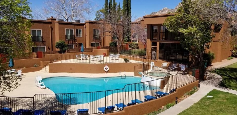 Poolside Amenities – A close-up of the pool area, showcasing lounge chairs and outdoor umbrellas, ideal for relaxation.