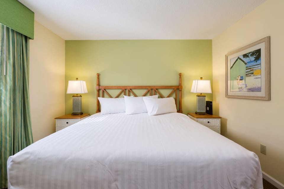 Relax in the cozy bedroom with a queen bed, offering a serene ambiance and convenient amenities for a perfect getaway at Sandy Shores III.