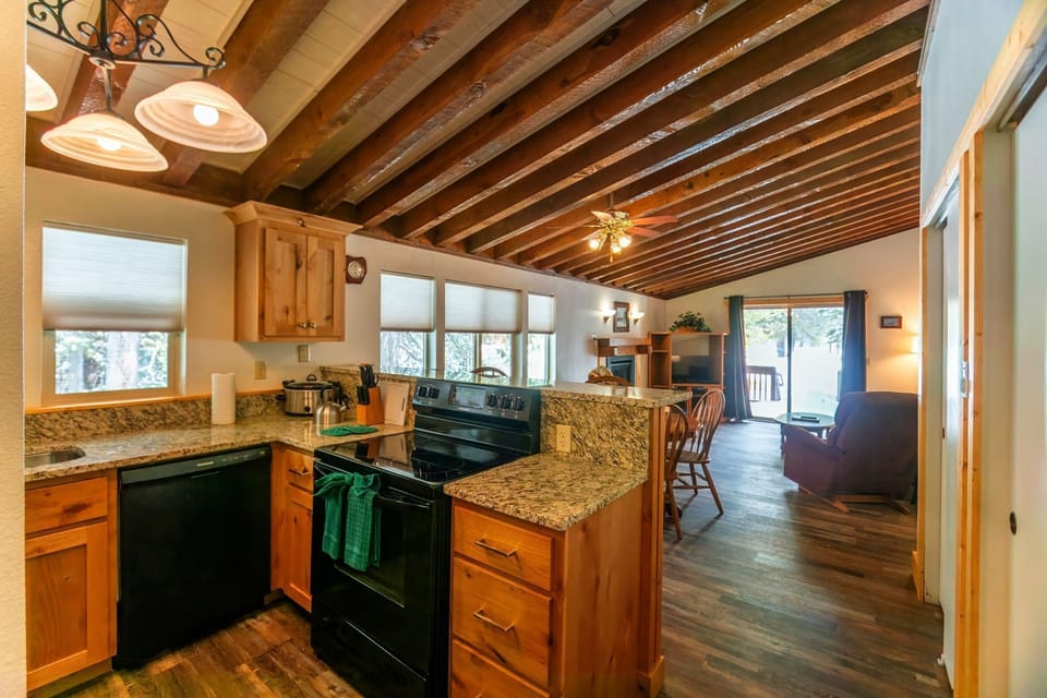 Experience cozy cooking in a fully equipped kitchen adorned with wooden beams, perfect for family meals and gatherings.